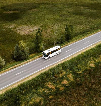 aerial-view-of-passenger-bus-on-road-through-count-D65UCAM